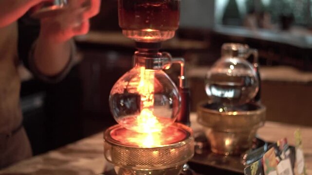 Preparing coffee with syphon in coffee shop.
