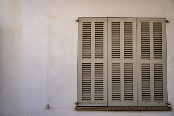 old window with shutters on the wall