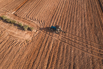 Aerial top view tractor plowing a field , preparing the land for a wheat planting operation.