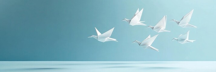 Six white origami birds gracefully soar in a zigzag formation against a light blue background, symbolizing freedom, hope, unity, peace, and the pursuit of dreams.