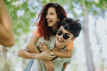 Joyful young adults enjoying a sunny day in the park, smiling and having fun together outdoors in a...