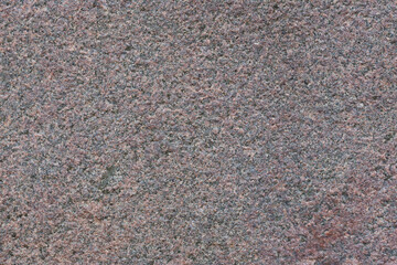 Granite texture. Natural pink granite with a grainy pattern. Stone background. Solid rough surface of rock. Durable construction and decoration material. Close-up.