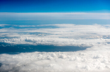 White cumulus clouds on clear blue sky background closeup, overcast skies backdrop, fluffy cloud texture, beautiful sunny cloudscape heaven. White clouds view from airplane
