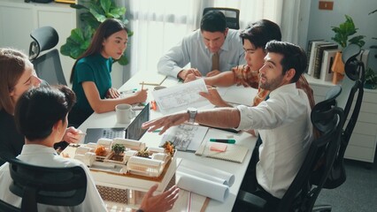 Top view of skilled civil engineer team compare between blueprint and house plan. Aerial view of group of architect or designer discussing and point note to brainstorm about blueprint. Alimentation.