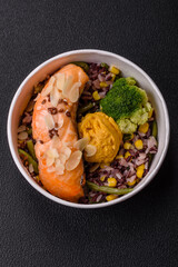 A piece of boiled salmon with rice, broccoli, salt and spices