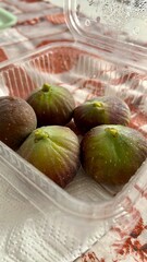 fichi in vaschetta trasparente su tavolo.