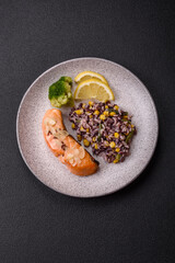 A piece of boiled salmon with rice, broccoli, salt and spices