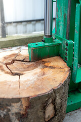 Wood splitter machine cracking a big tree slice, close up
