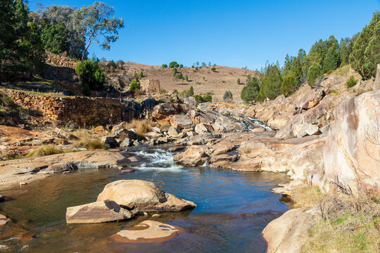 Photograph of water flowing in Adelong creek near the Adelong Falls Gold Mine ruins in the Snowy Mountains in New South Wales in Australia.