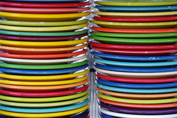 Stacks of colored plates on a shelf