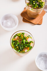 Trendy refreshing iced latte with green onions in glasses on the table vertical view