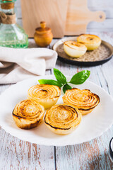 Caramelized roasted onions and basil on a plate on the table vertical view