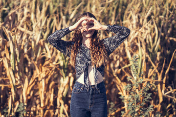 A Young Woman is Playfully Posing in a Beautiful Golden Field, Capturing the Essence of Summer