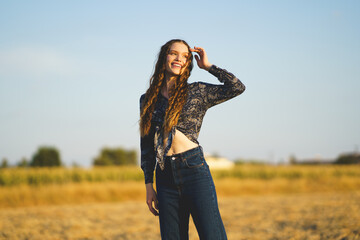 A Joyful Young Woman Enjoys a Beautiful Sunny Field with Her Unique Sense of Style