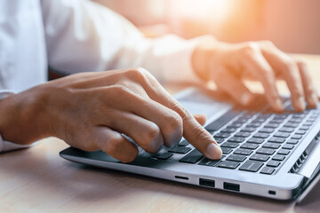 Businessman hand typing on computer keyboard of a laptop computer in office. Business and finance concept. uds