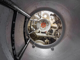 Old retro style red rotating wheel shutoff valve, escape hatch periscope and instrument panel on a...