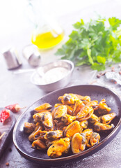 spicy stir fried mussel with slice onion and spice on plate