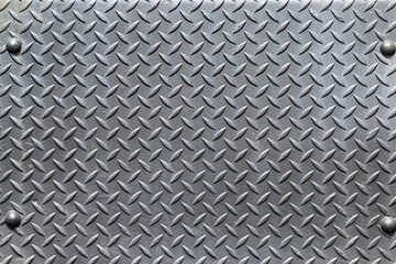 Closeup of a riveted with button-head rivets steel checkered plate as an industrial background