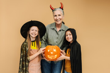 Happy family celebrating halloween with their grandmother holding a jack o'lantern