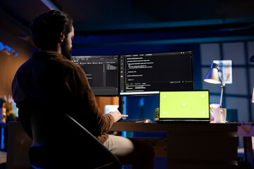 Developer working from home in apartment on green screen laptop, futureproofing company network...