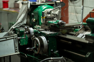 An old, well-used lathe machine in a workshop, a vital tool for metalworking and precision engineering tasks.