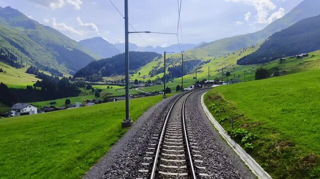 Rear View From Glacier Express on Railroad Tracks and Mountainscape and Valley in a Sunny Summer Day in Sedrun, Surselva, Oberalp, Grisons, Switzerland, Europe