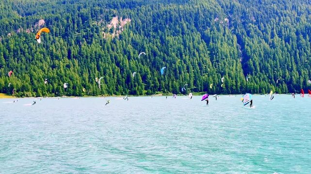People Kitesurfing and Wingsurfing on Alpine Lake Silvaplana with Mountain in a Sunny Summer Day in Silvaplana, St Moritz, Grisons, Switzerland, Europe