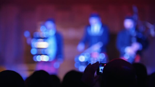 Spectators at concert - people shooting performance on smartphone, scottish musicians