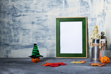 Photo frame surrounded by Halloween decorations, skeletons and colorful hats with pumpkins