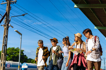 Group of Asian man and woman enjoy and fun outdoor lifestyle travel countryside by railroad transportation on summer holiday vacation. Generation z people friends walking together at train station.