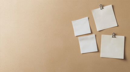 Fototapeta premium A white board with four pieces of paper attached to it. The board is on a tan background