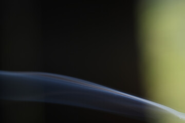 Smoke from the cigarette has a higher temperature than the surrounding giving it lower density which makes it rise