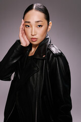 Asian woman black leather jacket posing hands on face fashionable and stylish portrait of an asian female model