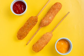 Korean corndog with a crispy golden crust, isolated on a vibrant yellow background. Perfect for recipe, article, catalogue, commercial, or any cooking content.