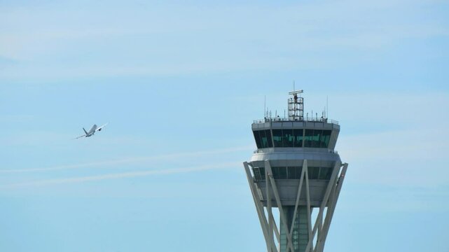 Airplane Taking Off Near Control Tower. A large commercial airplane takes off into the sky with a control tower visible in the foreground, capturing the dynamics of airport operations
