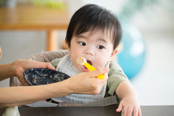 離乳食を食べる赤ちゃんとお母さん　クローズアップ