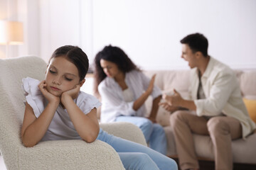 Fototapeta premium Divorce concept. Angry couple arguing at home, focus on their sad daughter