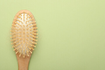 One brush with lost hair on light olive background, top view. Space for text