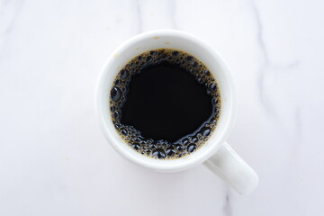 淹れたてのコーヒーが入ったマグカップを、真上から俯瞰した画像