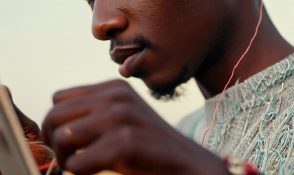 Mozambican Man Learning to Knit from Online Tutorial