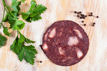 Sliced traditional Catalan black botifarra (pork blood sausage) with fresh parsley and peppercorns...