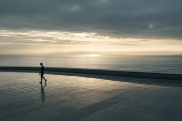 Fototapeta premium Solitary Stroll along the Ocean at Sunset on a Calm and Reflective Evening