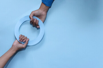World diabetes day awareness concept. Hands holding blue  circle of universal symbol for diabetes....