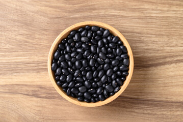 Black bean in bowl on wooden background, Table top view