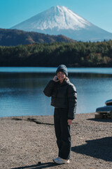 Woman tourist enjoy with Fuji Mountain at Lake Saiko, happy Traveler sightseeing Mount Fuji and road trip Fuji Five Lakes. Landmark for tourists attraction. Japan Travel, Destination and Vacation