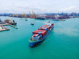 the aerial perspective of a cargo ship being loaded and unloaded at a bustling seaport and sailing out of the mainland