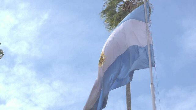 Bandera argentina flameando con el viento en cielo azul del mediod&iacute;a en buenos aires