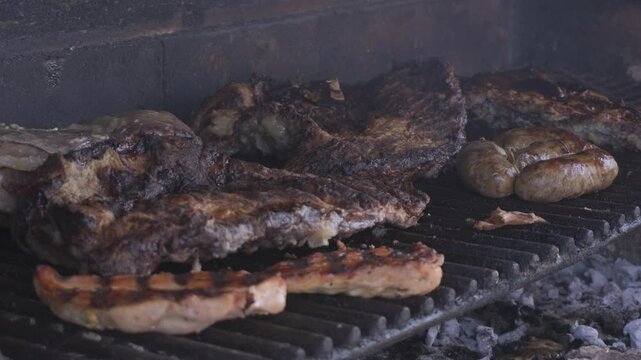 Asado argentino de carne cocin&aacute;ndose en parrilla encendida
