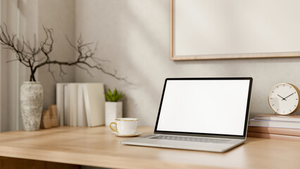 A laptop and minimal decorative objects on a wooden table in a minimal Scandinavian room.