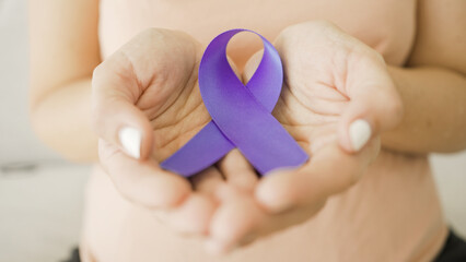 Hands holding purple ribbon, Alzheimer's disease, Pancreatic cancer, Epilepsy awareness, world...